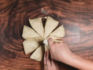 Cutting dough into basic dinner rolls.