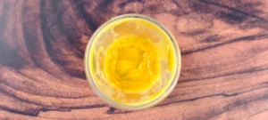 A blender jar filled with pureed fresh mangoes and coconut cream.