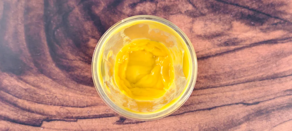 A blender jar filled with pureed fresh mangoes and coconut cream.