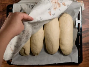 Sub sandwich rolls after resting under a kitchen towel.