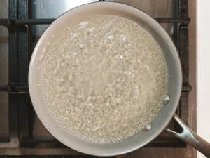 Simmering classic simple syrup in a pan.
